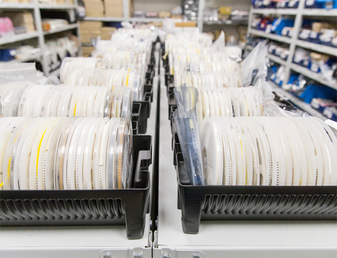 SMD-Bauteile auf Gurtrollen im Lager einer Elektronikfertigung